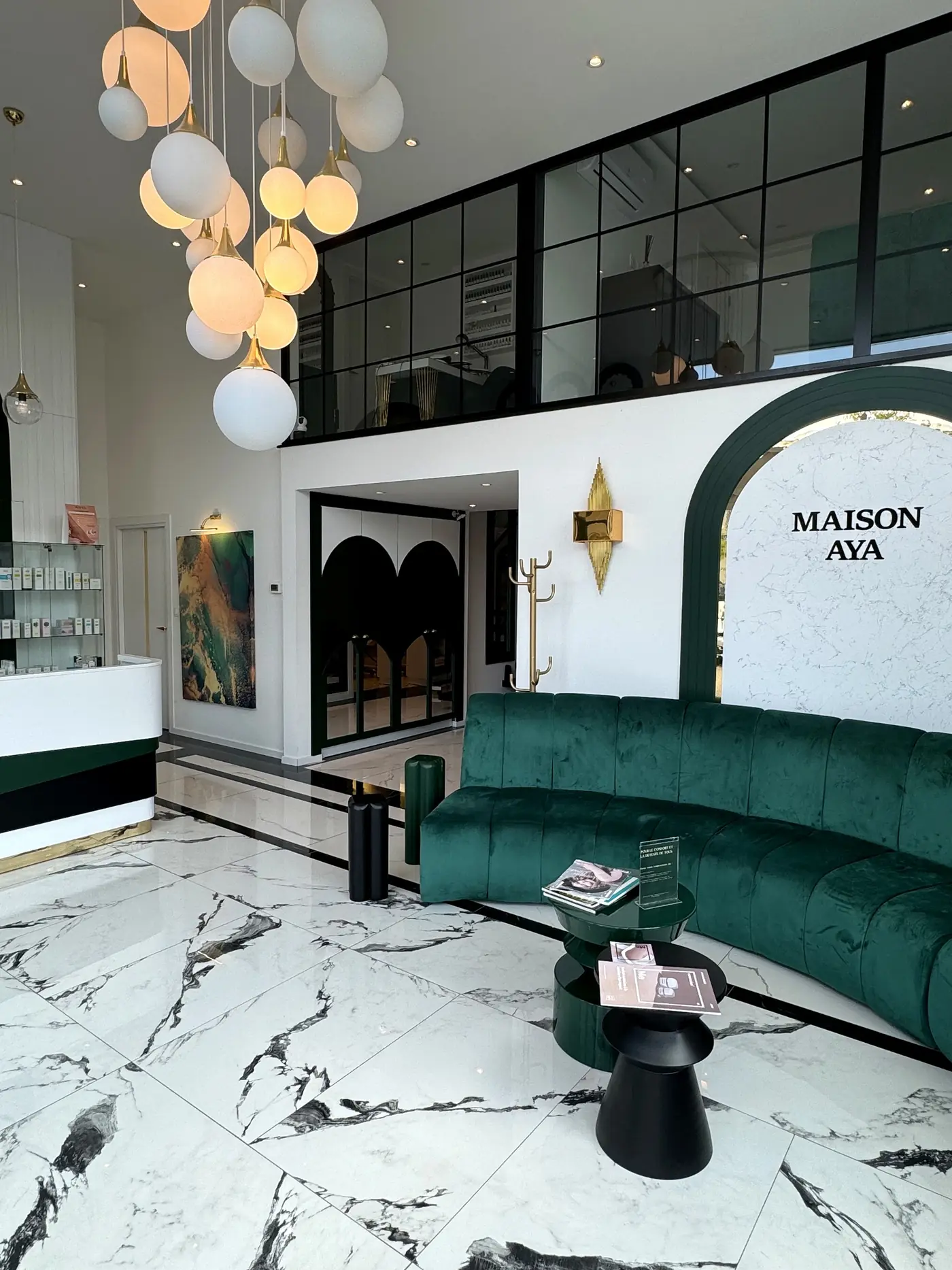 Accueil lumineux de Maison Aya, décoré de vert profond, de marbre et de touches dorées