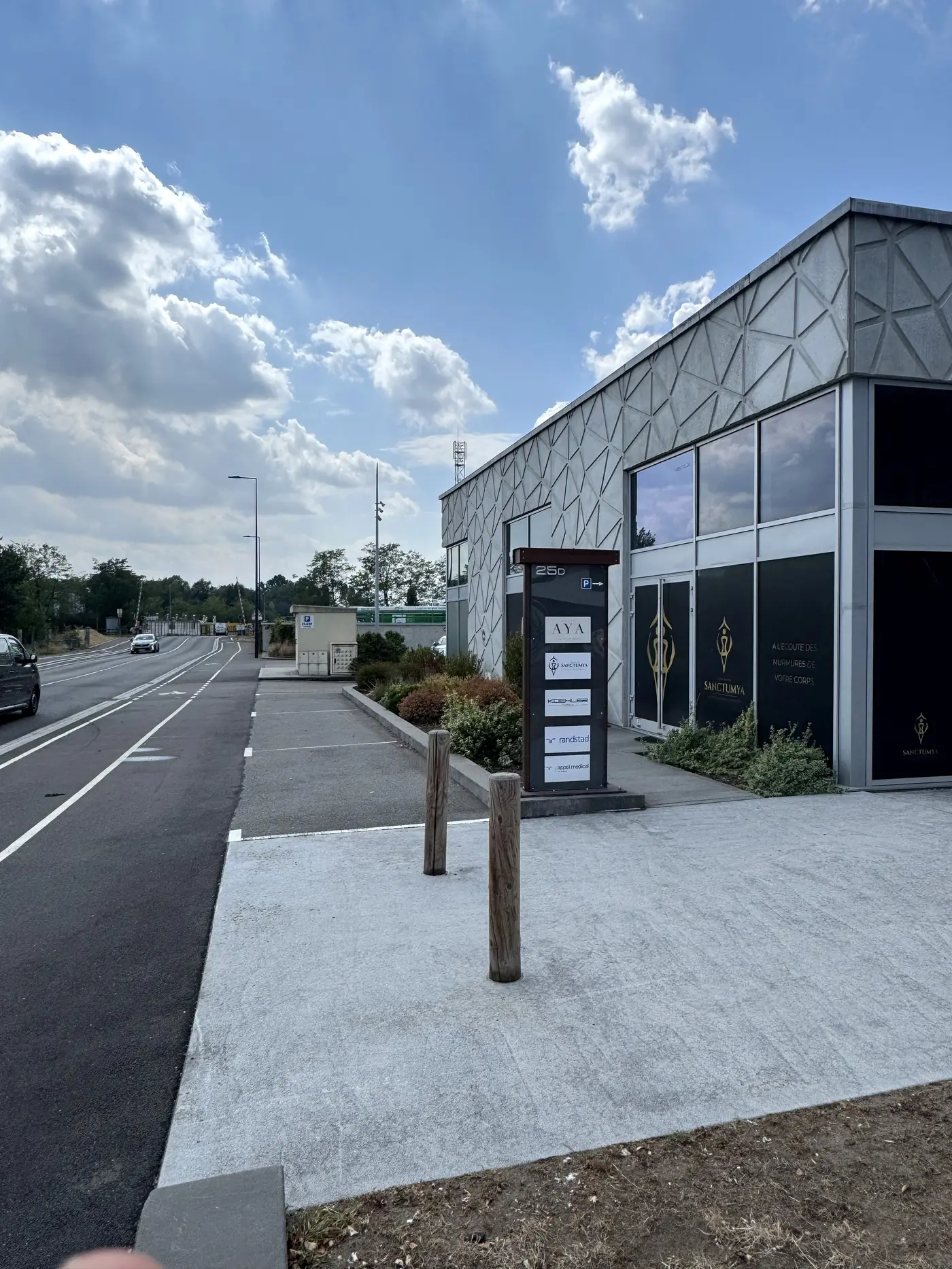 Entrée de Maison Aya et panneau indiquant le parking client